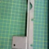Imagen de bisagra de tapa frontal para fileteadora KC-24, fabricada con materiales resistentes para un ajuste preciso y duradero.